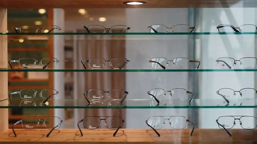 Montures de lunettes exposées sur des étagères en verre
